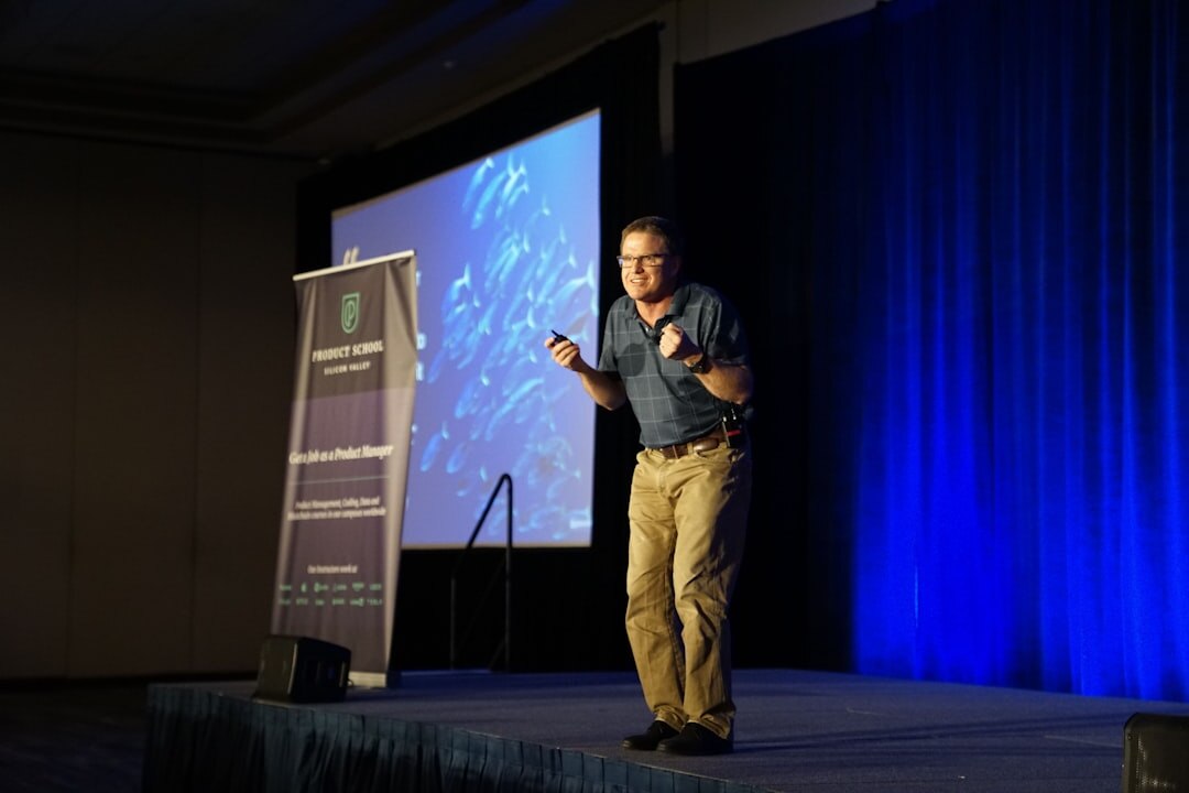 Speaker addressing an audience on a business conference stage